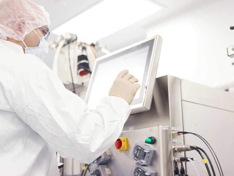 Photo of a cleanroom worker double checking data on a display. 